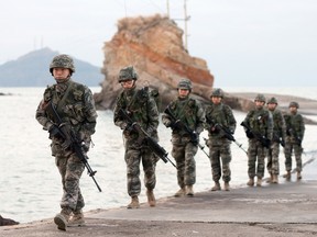 South Korean soldiers patrol on the South-controlled island of Yeonpyeong near the disputed waters of the Yellow Sea at dawn on November 21, 2013.