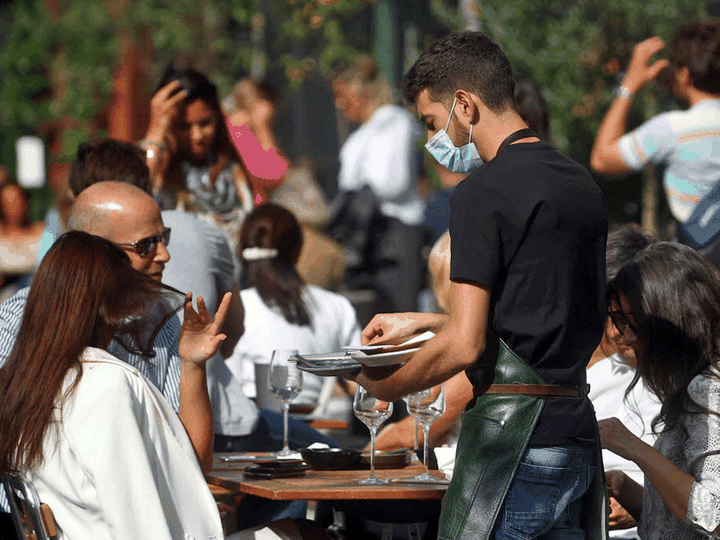  A waiter wears a mask as he works during the COVID-19 pandemic in London, England, September 22, 2020.