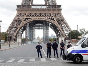 French police stand near the Eiffel Tower after the French tourism landmark was evacuated following a bomb alert in Paris, France, September 23, 2020.