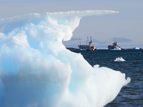 Ships are framed by pieces of melting sea ice in Frobisher Bay in Iqaluit, Nunavut on Wednesday, July 31, 2019. Satellite pictures say Arctic sea ice is now at its second-lowest level in more than four decades.