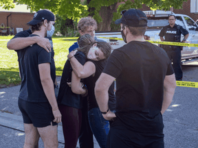 Friends of victims in a shooting at a home in Oshawa, Ont. react after laying flowers on Friday September 4, 2020.