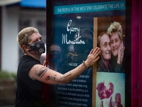 Samantha Monckton touches a memorial for her late 77-year-old father Garry Monckton, who died in April after becoming infected with COVID-19, after unveiling it in Vancouver, B.C., Tuesday, Sept. 15, 2020. The tribute to Monckton is the first of a series of memorial posters paying tribute to residents of Vancouver's West End who have died from COVID-19.