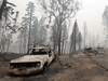 A burnt vehicle is pictured beside a fire-ravaged home during the Creek fire in Auberry, California on September 11, 2020.