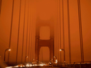 Cars drive along the Golden Gate Bridge under an orange smoke filled sky at midday in San Francisco, California on September 9, 2020. More than 300,000 acres are burning across the state from 35 major wildfires, with at least five towns 