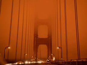 Cars drive along the Golden Gate Bridge under an orange smoke filled sky at midday in San Francisco, California on September 9, 2020. More than 300,000 acres are burning across the state from 35 major wildfires, with at least five towns "substantially destroyed."