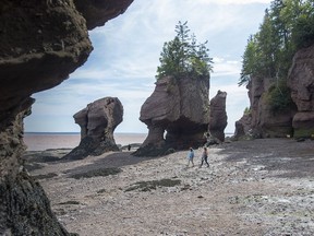Visitors stroll at Hopewell Rocks in Hopewell Cape, N.B., Sunday, Sept. 13, 2020. The rock formations are caused by tidal erosion along the Bay of Fundy. New Brunswick voters go to the polls on Monday for the first provincial election during the COVID-19 pandemic.