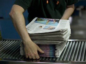 An employee stacks newspapers at the Toronto Star printing plant in Toronto, Ontario, Canada, on Wednesday, July 6, 2011.