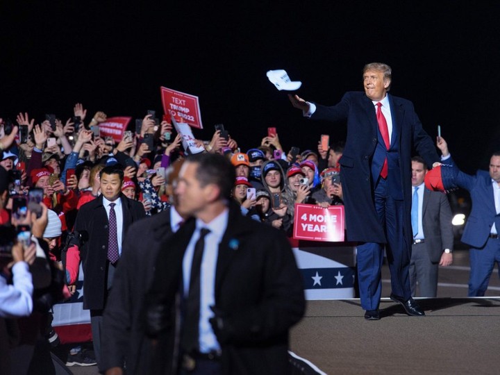  U.S. President Donald Trump tosses a cap to supporters as he arrives for a campaign rally at Duluth International Airport in Duluth, Minnesota on September 30, 2020.