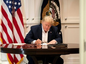 This White House handout photo released October 4, 2020 shows U.S. President Donald Trump working in the Presidential Suite at Walter Reed National Military Medical Center in Bethesda, Maryland on October 3, 2020, after testing positive for COVID-19. (