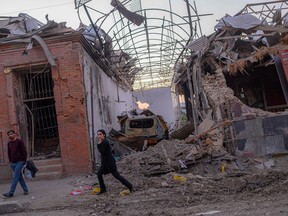 Local residents walk in a street after it was hit by a missile in Gandja, Azerbaijan, on Oct. 8.