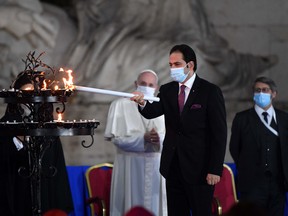 Secretary General of the Higher Committee of the Human Fraternity Mohamed Abdelsalam Abdellatif, centre, flanked by Pope Francis, left, and Chief Rabbi of France Haim Korsia, lights a candle during a ceremony for peace with representatives from various religions at Campidoglio Square, in Rome, on Oct. 20.