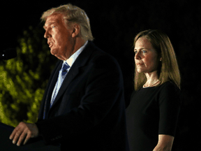 Judge Amy Coney Barrett listens as U.S. President Donald Trump speaks before she is sworn in to the U.S. Supreme Court at the White House, October 26, 2020.