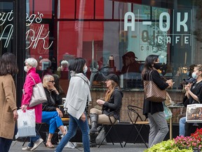 Pedestrians walk past a coffee shop on Toronto's Bloor Street during the COVID-19 pandemic, on Sept. 17, 2020.