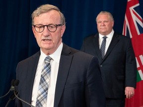 Ontario's Chief Medical Officer of Health, Dr. David Williams, speaks during a news conference about the coronavirus pandemic, while Premier Doug Ford listens, in a May 29, 2020, file photo from Queen's Park in Toronto.