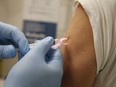 Shoppers Drug Mart pharmacist Abdeen Salim Hamid administers the flu shot at the Coxwell and Danforth Aves. location on Monday October 19, 2020. PHOTO BY JACK BOLAND/TORONTO SUN/POSTMEDIA NETWORK.