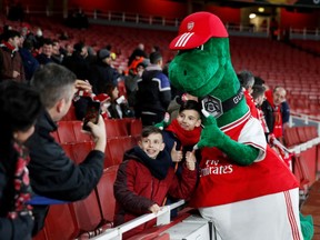 Arsenal mascot Gunnersaurus poses for a photograph with fans inside the stadium before the match, Feb 27. 2020. PHOTO BY DAVID KLEIN/REUTERS