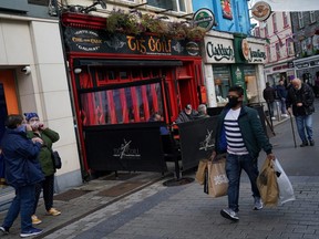 A shopper wearing protective face mask walks through the street in the City centre of Galway, Ireland, October 5, 2020.