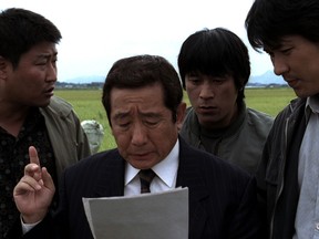 Gather round: From left, Song Kang-ho, Kim Sang-kyung and Kim Roe-ha listen to the chief.