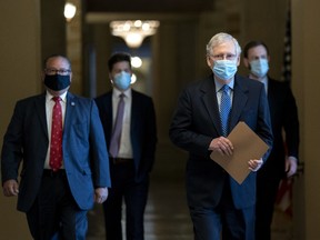 Senate Majority Leader Mitch McConnell, a Republican from Kentucky, second right, wears a protective mask while walking to the Senate Chamber at the U.S. Capitol in Washington, D.C., U.S. on Thursday, Oct. 1, 2020.