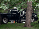 An RCMP police officer looks in the cab of a pickup truck on the grounds of Rideau Hall on July 2. A man who had trafficked in QAnon material was charged with ramming the truck into the grounds of the prime minister.