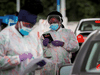 Medical technicians work at a drive-through COVID-19 testing facility at the Regeneron Pharmaceuticals company’s Westchester campus in Tarrytown, New York, September 17, 2020.