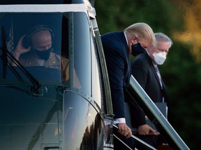 White House Chief of Staff Mark Meadows (R) watches as US President Donald Trump walks off Marine One after arriving at Walter Reed Medical Center in Bethesda, Maryland on October 2, 2020.