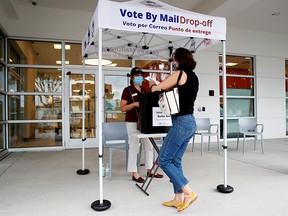 Katie Tricarico casts her mail-in ballot in the U.S. presidential election at a public library in East Tampa, Florida, U.S., August 16, 2020.