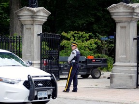 A police officer stands near a damaged gate at Rideau Hall, the property where Canadian Prime Minister Justin Trudeau lives, after an armed man rammed the gate with a pickup truck to gain access to the grounds.