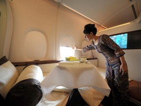 Sharmala Huey Yuen, a Singapore Airlines Ltd. flight steward, opens a window shade in the luxury class suite during a media tour of the new A380 superjumbo aircraft, at Melbourne International Airport in Melbourne, Australia, on Wednesday, Sept. 30, 2009.