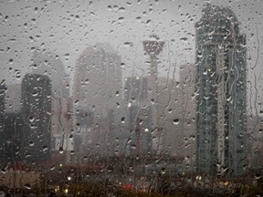 Calgary's city skyline is seen through a rainy window from Scotchman's Hill in Calgary, Alta., on Thursday October 10, 2013. A mostly sunny day gave way to evening rain that later turned into heavy, wet snow south of the city.