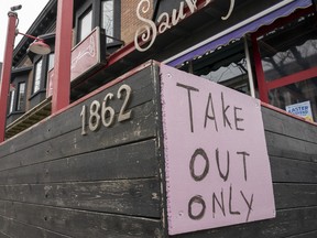 A restaurant in Toronto displays a "Take Out Only" sign on Wednesday, March 18, 2020.