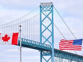 Canadian and American flags fly near the Ambassador Bridge at the Canada/USA border crossing in Windsor, Ont. on Saturday, March 21, 2020.