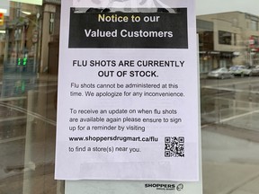 Sign in window of Shoppers Drug Mart in downtown Ottawa tells customers that flu shots are out of stock. Tuesday, Oct. 13, 2020.