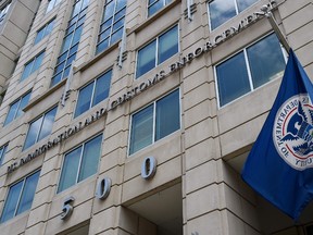 n this file photo taken on July 17, 2020 the Department of Homeland Security flag flies outside the Immigration and Customs Enforcement (ICE) headquarters in Washington, DC.