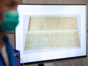 Police show a picture of a calligraphy scroll written by Mao Zedong.