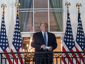 U.S. President Donald Trump holds his protective mask on the Truman Balcony of the White House in Washington, D.C., U.S., on Monday, Oct. 5, 2020.
