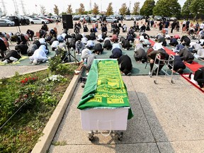 People pray behind the casket of Mohamed-Aslim Zafis during his funeral in Toronto on Wednesday, September 16, 2020.