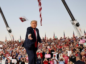 U.S. President Donald Trump throws a face mask from the stage during a campaign rally, his first since being treated for the coronavirus disease (COVID-19), at Orlando Sanford International Airport in Sanford, Florida, U.S., October 12, 2020.