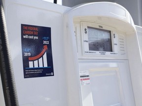 A gas pump displays an anti-carbon tax sticker in Toronto on Thursday, August 29, 2019. The Ontario government says it will not appeal a court ruling against its anti-carbon tax stickers.Energy Minister Greg Rickford's office says in a statement that the province will abide by the decision.