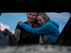 Members of the Lebaron family mourn while they watch the burned car where part of the nine murdered members of the family were killed and burned during an gunmen ambush on Bavispe, Sonora mountains, Mexico, on November 5, 2019.