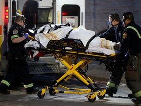 Paramedics wear respirators while responding to a medical call, amid the outbreak of the coronavirus disease (COVID-19), in downtown Winnipeg, Manitoba, November 1, 2020.