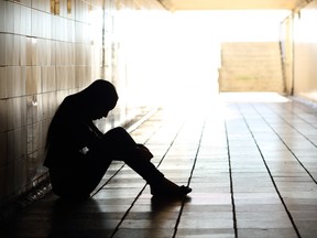 Teenager depressed sitting inside a dirty tunnel