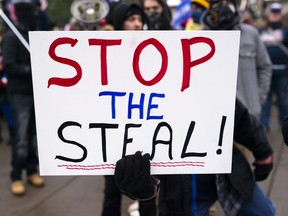 A person holds a sign that says "Stop the Steal!" as supporters of President Donald Trump gather for a rally outside the Governor's Mansion on November 14, 2020 in St Paul, Minnesota.