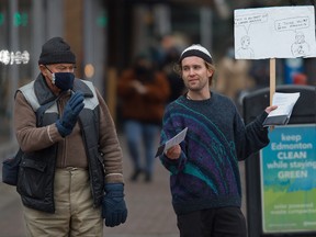 A man hands out anti-mask pamphlets in Edmonton on Oct. 30.