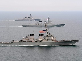 This March 17, 2013 US Navy handout image shows the Arleigh Burke-class guided-missile destroyer USS John S. McCain (DDG 56)(Front), the Republic of Korea Navy Aegis-class destroyer ROKS Seoae-Yu-Seong-Ryong (DDG 993), (C) and the Arleigh Burke-class guided-missile destroyer USS McCampbell (DDG 85) moving into formation in the waters off the Korean Peninsula during exercise Foal Eagle 2013.