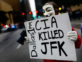 A protester stands outside the John F. Kennedy Memorial Plaza in Dallas in 2013.