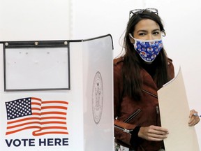 Congresswoman Alexandria Ocasio-Cortez holds her filled ballot as she votes early at a polling station in New York City, on Oct. 25.