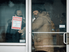 Adamson BBQ's Adam Skully is forced to place a closed sign on the Toronto restaurant after defiantly opening to indoor diners despite the COVID-19 lockdown, Tuesday November 24, 2020.