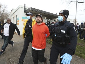 Adamson BBQ owner Adam Skelly is led away from his restaurant by Toronto Police on Nov. 26.