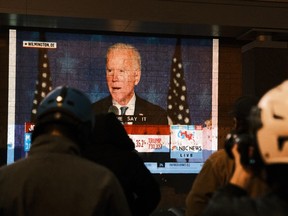 People watch Biden give a speech shortly after midnight on Election Day on November 4, 2020 in Washington, DC. PHOTO BY EZE AMOS/GETTY IMAGES.